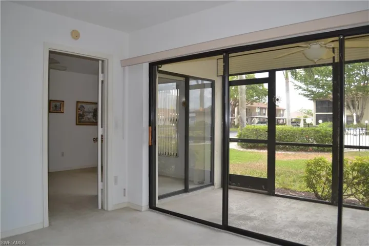 Doorway to outside with ceiling fan and carpet floors