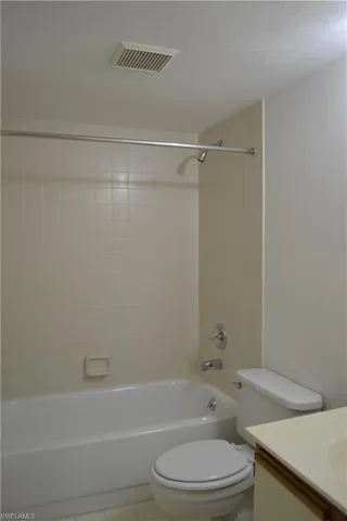 Bathroom featuring vanity, washtub / shower combination, and tile patterned floors