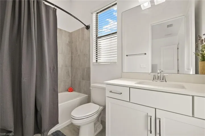 White vanity with an integrated sink, polished chrome faucet, and rectangular mirror