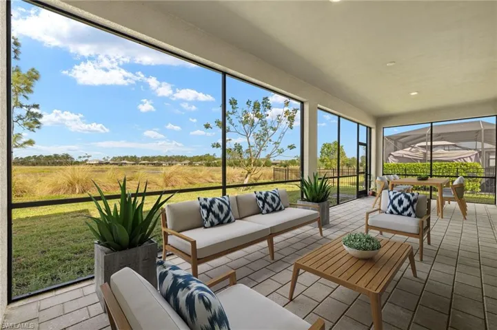 Screened-in covered patio featuring paver flooring, recessed lighting, and expansive outdoor living space