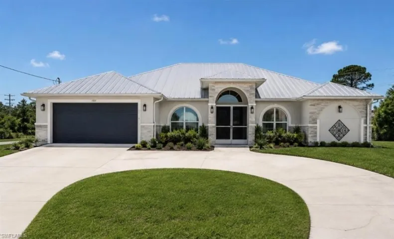 Home idea with exterior stone accents, covered entry, and a metal roof.