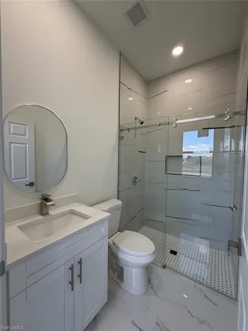 White vanity with a light-toned countertop, under-mount sink, and contemporary faucet