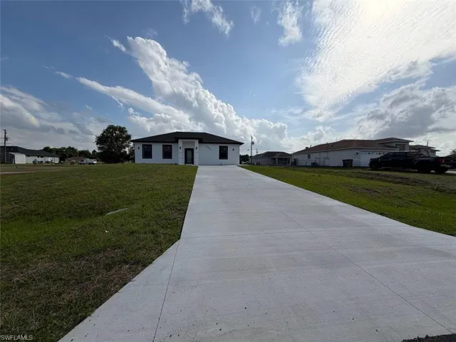 Single-story residence featuring a dark shingle roof, white exterior with dark trim windows, and a dark entry door