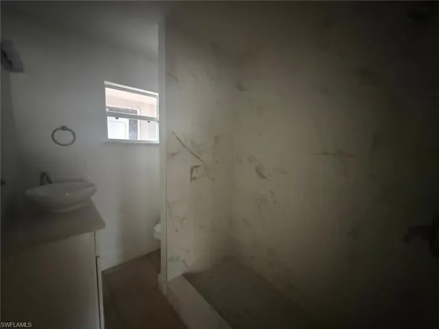 Full bathroom featuring vanity and a marble finish shower