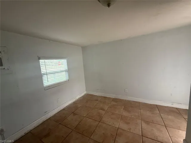 Unfurnished room with baseboards and tile patterned floors