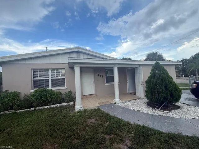 View of front of home featuring covered porch and stucco siding