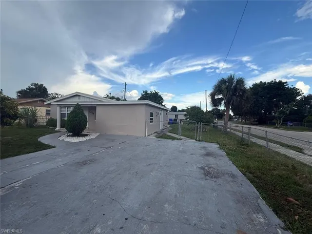 View of side of property with a gate and stucco siding