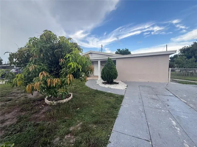 View of front of house with stucco siding and a patio area