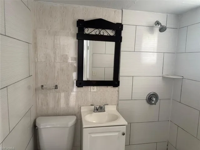 Bathroom featuring tile walls and vanity