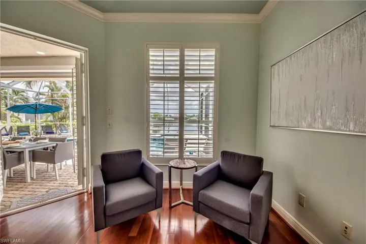 Sitting room with ornamental molding, wood-type flooring, and a sunroom