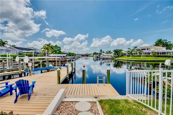 Dock featuring a water view, boat lift, and a residential view