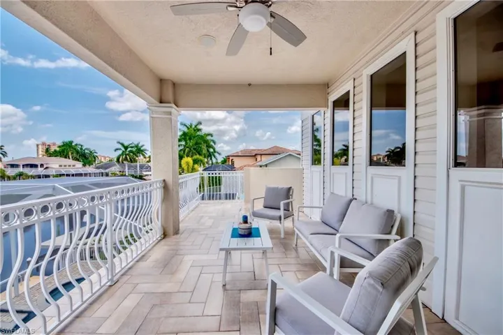 Balcony with a sunroom, ceiling fan, and outdoor lounge area