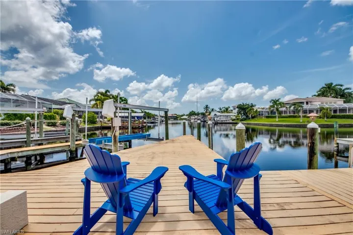 Dock featuring boat lift, a water view, and a residential view