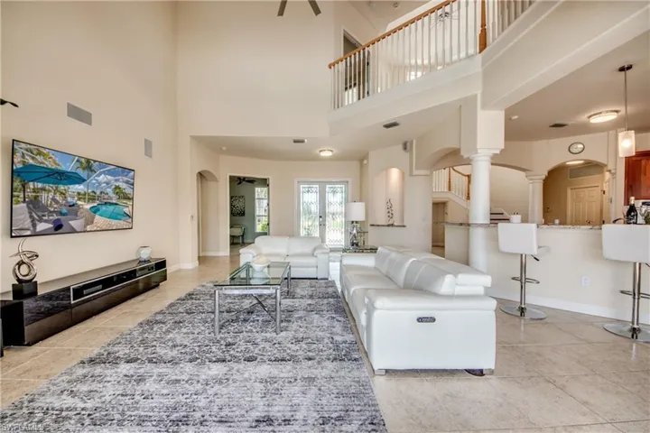 Living area with arched walkways and a high ceiling