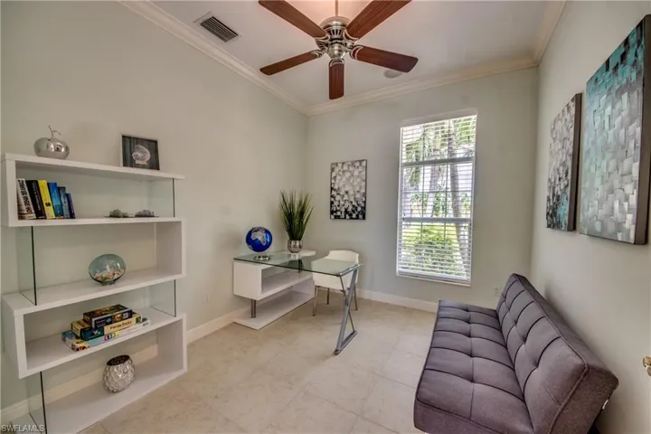 Home office with ornamental molding, light tile patterned floors, and a ceiling fan