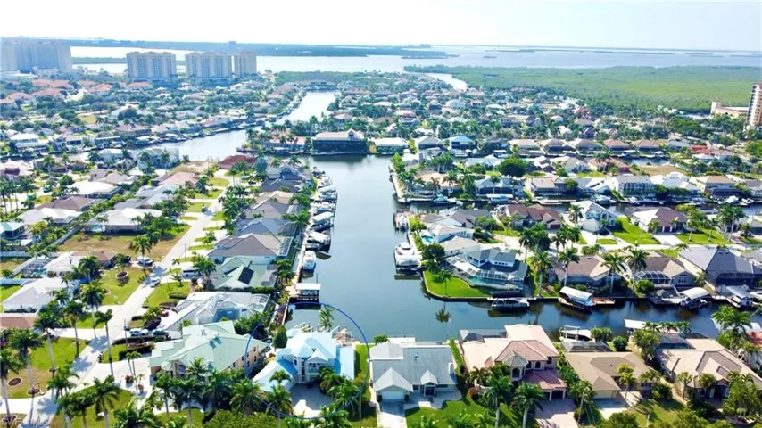 Aerial view of property and surrounding area featuring a nearby body of water and nearby suburban area