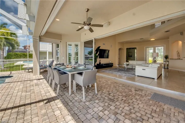 View of patio / terrace with an outdoor hangout area, a ceiling fan, glass enclosure, french doors, and outdoor dining space