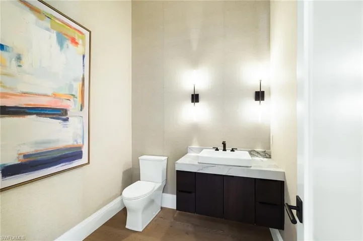 Half bath with vanity and dark wood-style flooring