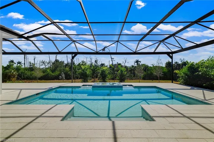 Integrated pool / hot tub featuring a sunroom, a lanai, and a patio area