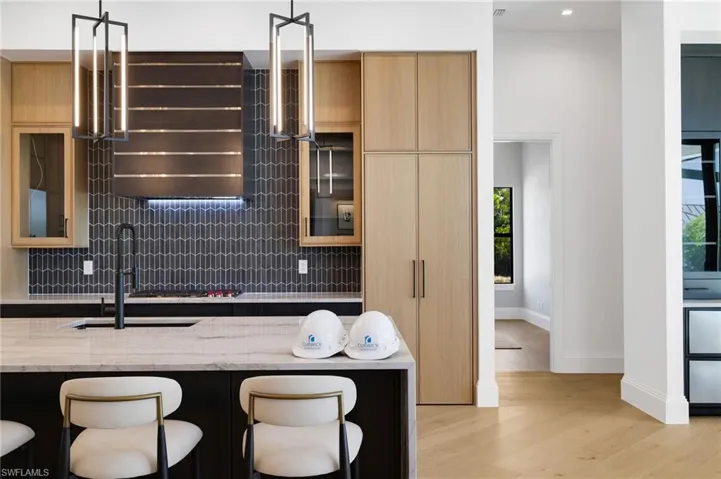 Kitchen featuring a breakfast bar area, modern cabinets, light stone counters, light wood-style flooring, and light wood finish cabinetry