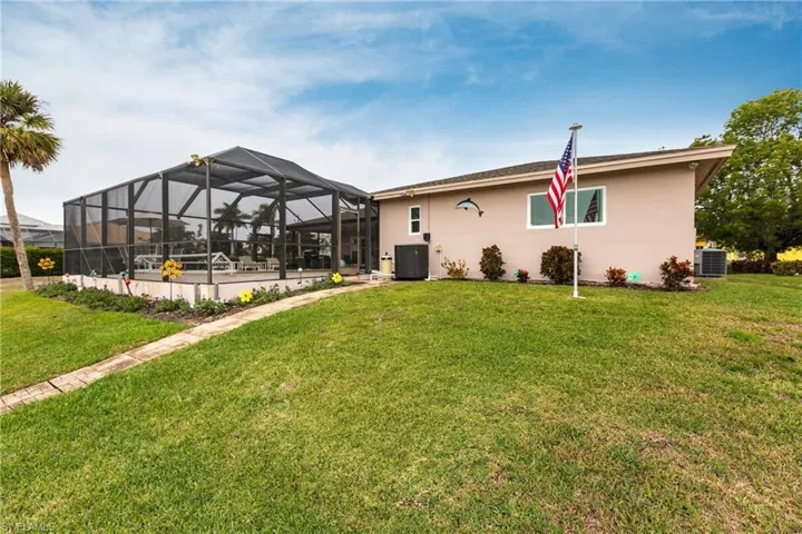 Back of property with a yard and central air condition unit