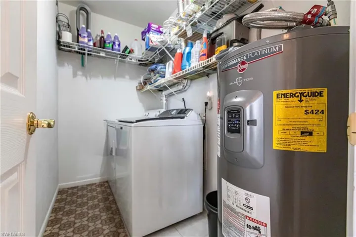 Washroom with washer and clothes dryer and water heater