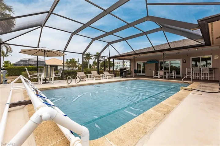 View of pool with a lanai and a patio