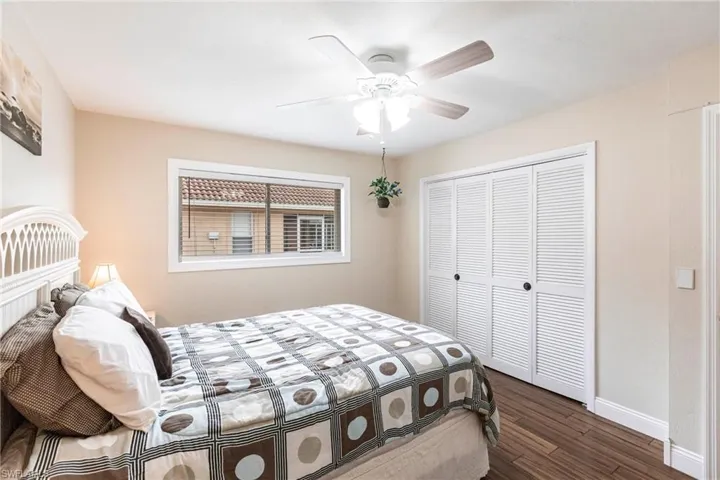 Bedroom featuring dark wood-type flooring, a closet, and ceiling fan