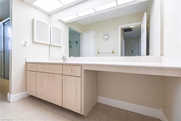 Bathroom featuring tile patterned flooring, a skylight, and vanity