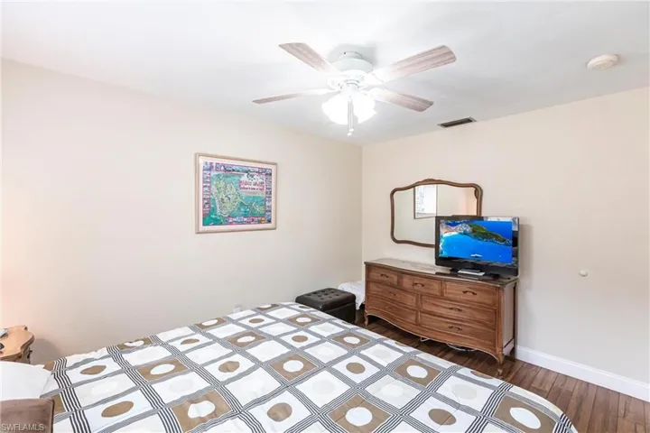 Bedroom featuring ceiling fan and dark hardwood / wood-style floors