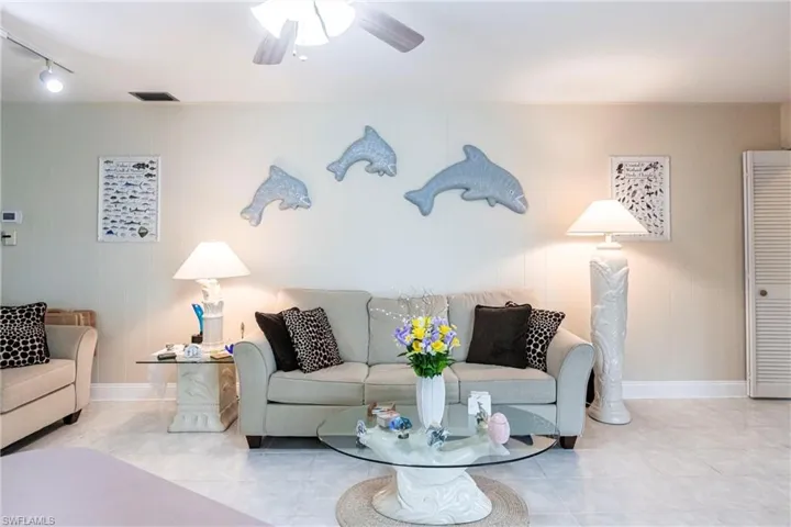 Living room with light tile patterned flooring and ceiling fan