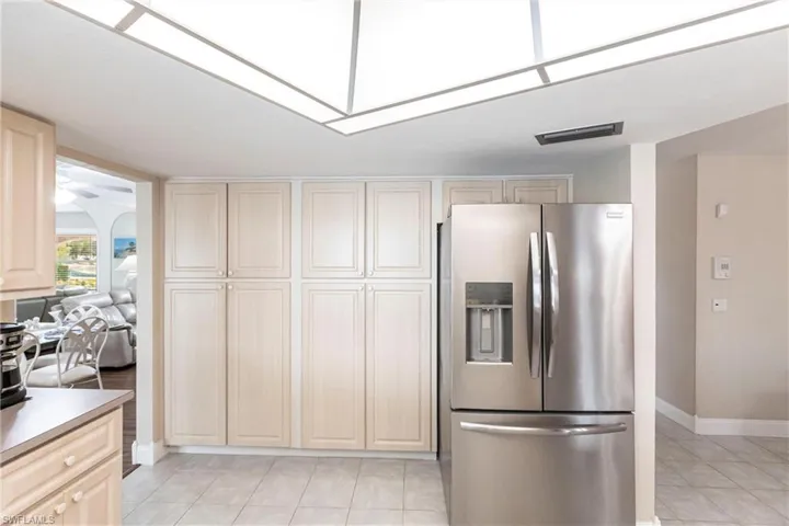 Kitchen featuring stainless steel refrigerator with ice dispenser and light tile patterned floors