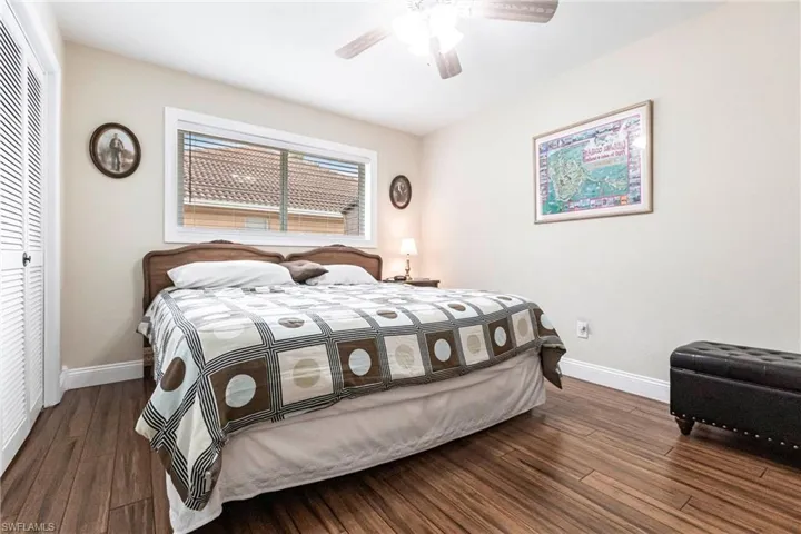 Bedroom featuring dark wood-type flooring, a closet, and ceiling fan