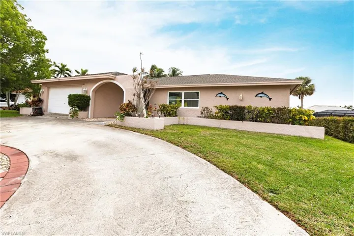 Ranch-style home featuring a garage and a front lawn