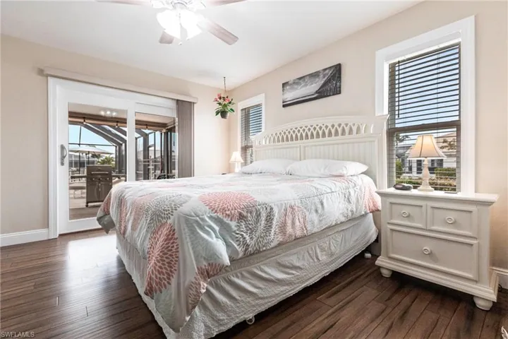Bedroom with ceiling fan, dark hardwood / wood-style floors, and access to outside