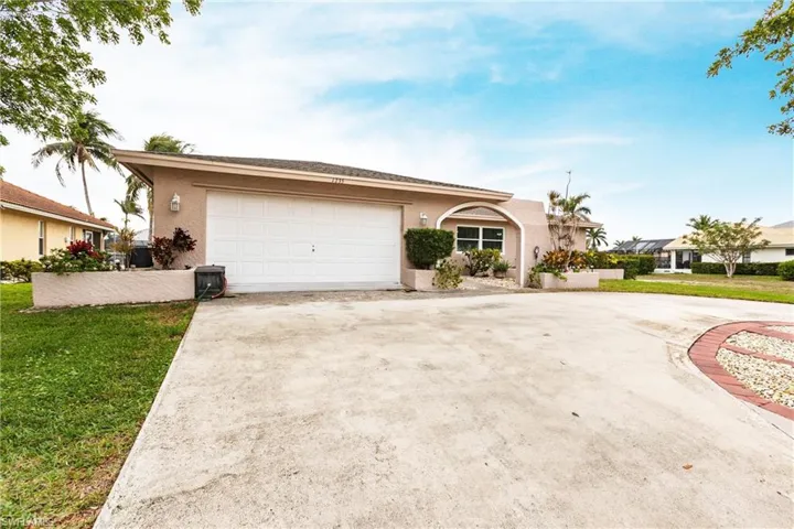 Ranch-style home featuring a garage and a front lawn