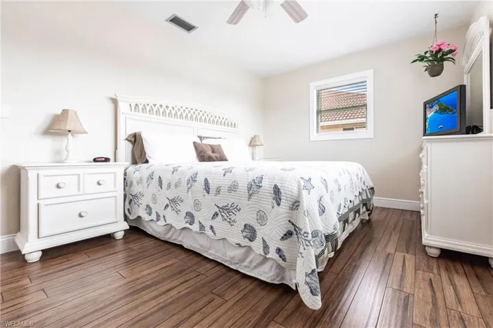 Bedroom with dark wood-type flooring and ceiling fan