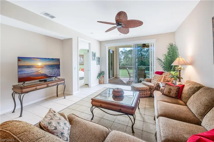 Living room featuring light tile patterned floors, baseboards, visible vents, and a ceiling fan