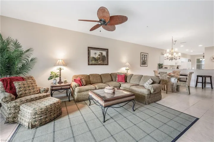 Living area featuring recessed lighting, light tile patterned flooring, and ceiling fan with notable chandelier