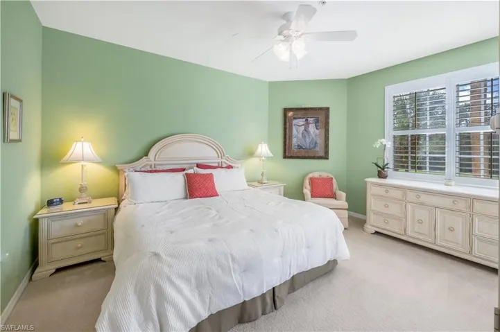 Bedroom with baseboards, a ceiling fan, and light colored carpet