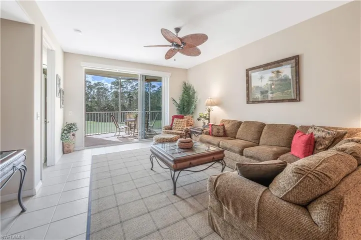 Living area with a ceiling fan and light tile patterned floors