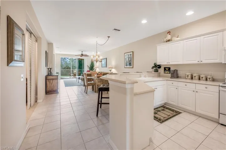 Kitchen with visible vents, open floor plan, a peninsula, a sink, and light tile patterned flooring