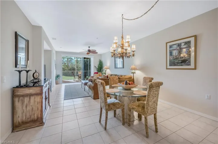 Dining area featuring baseboards, ceiling fan with notable chandelier, visible vents, and light tile patterned flooring