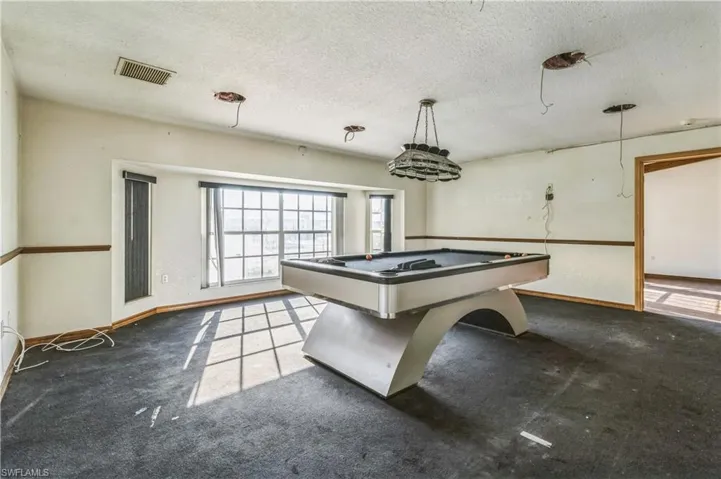 Rec room featuring a textured ceiling, carpet flooring, and billiards