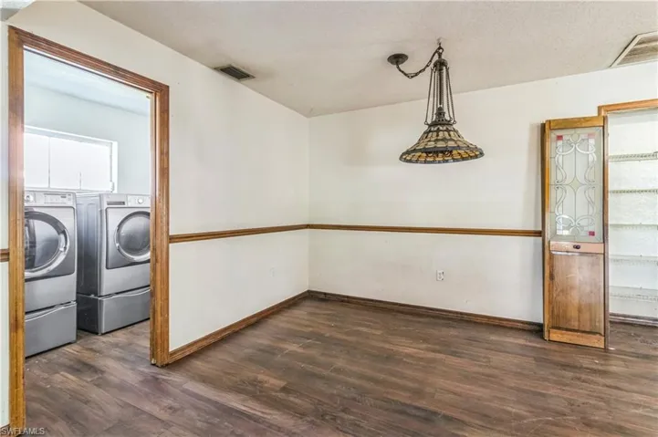 Washroom featuring dark wood-type flooring, washing machine and dryer, and a textured ceiling
