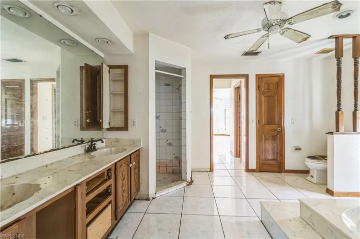 Full bathroom featuring a textured ceiling, separate shower and tub, toilet, tile patterned floors, and vanity