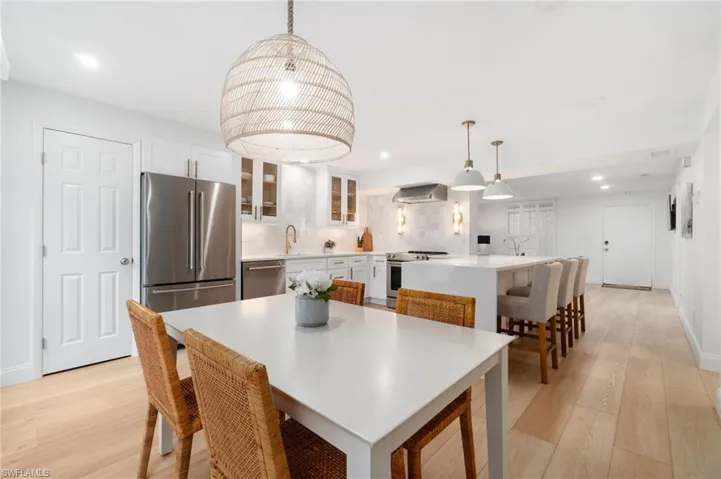 Dining room with light wood-style floors and recessed lighting
