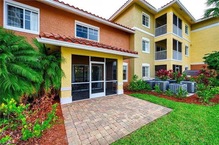 Back of house with a lakefront balcony, a patio area.