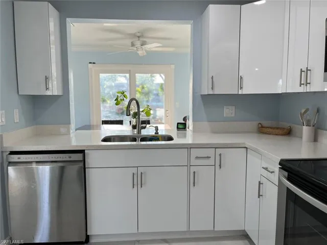 Kitchen with ceiling fan, white cabinetry, sink, and appliances with stainless steel finishes