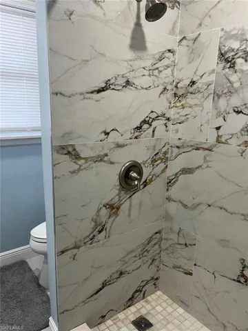 Bathroom featuring toilet and tiled shower